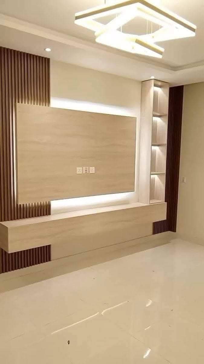 TV feature wall with built-in cabinetry and concealed lighting in a Doha living room (view 5)